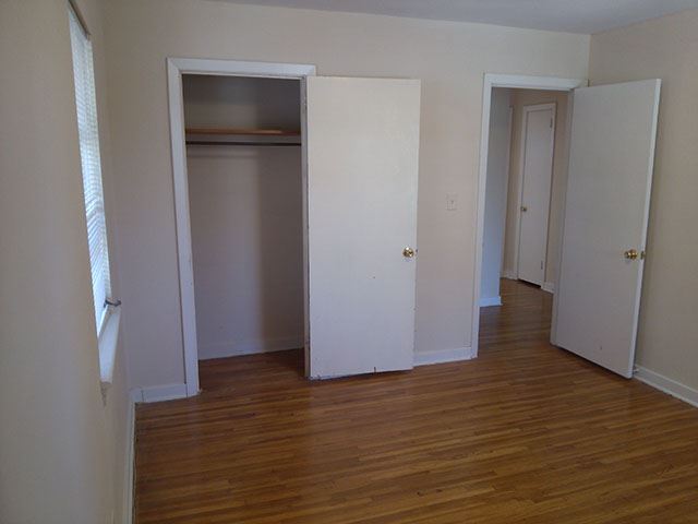 an empty room with three closets and a wood floor